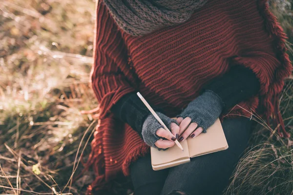 Vrouw schrijven in het notitieblok — Stockfoto