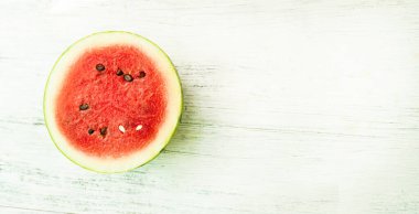 Slice of ripe watermelon on white wood table, summer concept.
