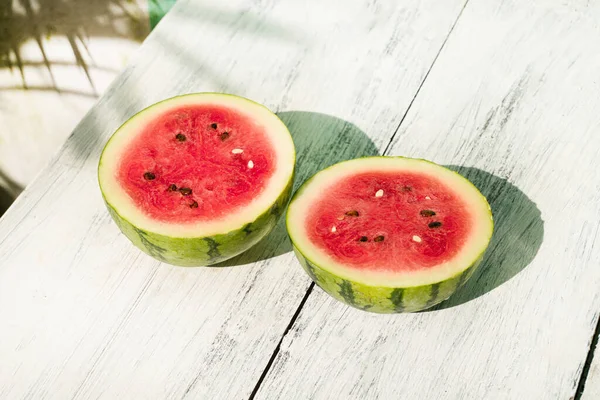 Slice of ripe watermelon on white wood table, summer concept.