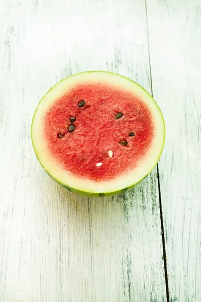 Slice of ripe watermelon on white wood table, summer concept.
