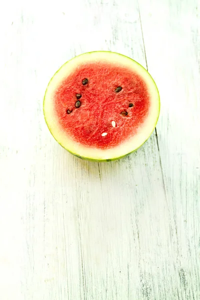 Slice of ripe watermelon on white wood table, summer concept.