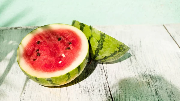 Slice of ripe watermelon on white wood table, summer concept.
