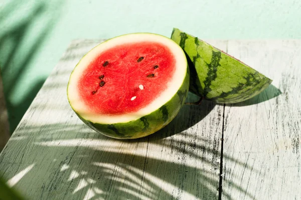Slice of ripe watermelon on white wood table, summer concept.