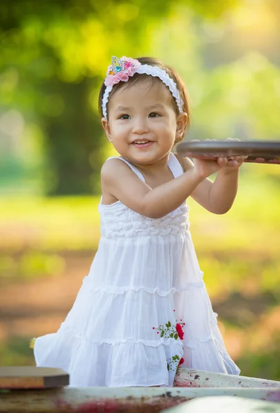 Bambina nel parco con parco giochi — Foto Stock