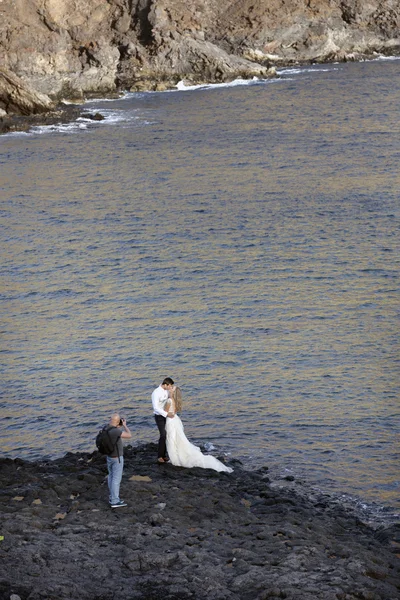 Menyasszony és a vőlegény esküvői kép n Tenerife a sziklás strand — Stock Fotó