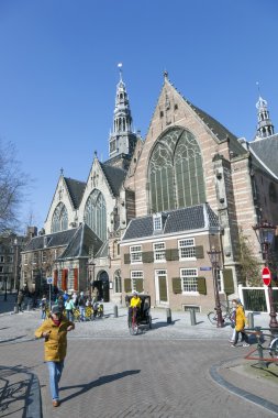 Amsterdam, Hollanda, 17 Mart 2016: a eski merkezinde old church yakınındaki sarı bisiklet ile turistler