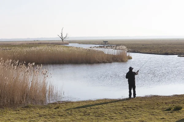 Pescador solitário com haste de fishong na paisagem holandesa — Fotografia de Stock
