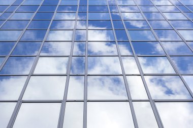 Mavi gökyüzü ve bulutlar cam ofis cephe yansıtır