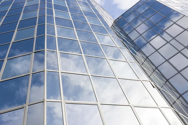 Fachada de escritório de vidro reflete nuvens e céu azul — Fotografia de Stock