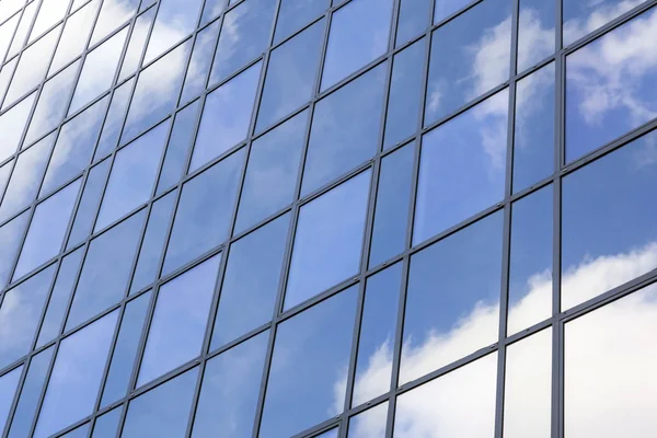 Mavi gökyüzü ve bulutlar cam ofis cephe yansıtır