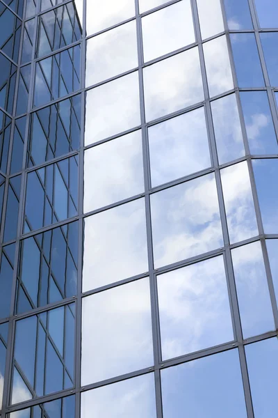 Fachada de oficina de cristal refleja nubes y cielo azul — Foto de Stock