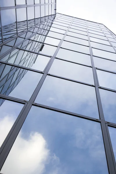 Edifício de vidro moderno com reflexos do céu azul e nuvens — Fotografia de Stock