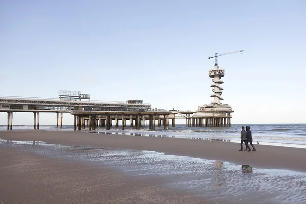 Paar wandelingen op lege strand in de buurt van pier van scheveningen — Stockfoto