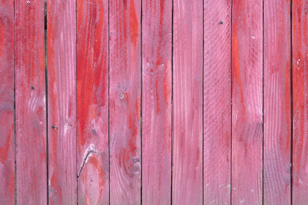 Vertical planks of red painted worn planks on fence or door — Stock Photo, Image