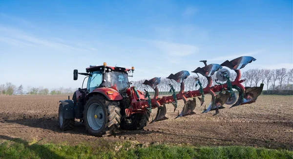 オーバーフラッキー島のオランダでは早春の畑に耕すトラクター — ストック写真
