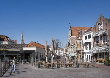 zierikzee, Hollanda, 30 Mart 2021: Eski şehir Zierikzee 'de meydanda adam ilkbaharda mavi gökyüzünün altında