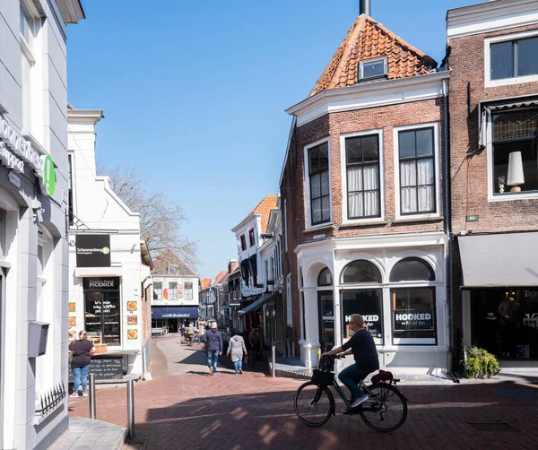 zierikzee, Hollanda, 30 Mart 2021: İnsanlar mavi gökyüzü altında eski şehir Zierikzee 'nin merkezinde bahar güneşinin tadını çıkarıyorlar.