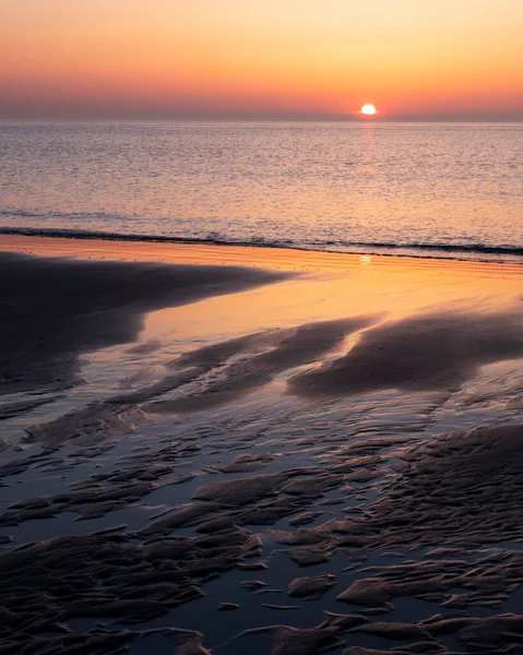 Padrão na areia e reflexão colorida de pôr do sol na água — Fotografia de Stock