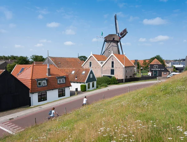 Pueblo de oudeschild con molino de viento en la isla holandés de texel visto desde el dique — Foto de Stock