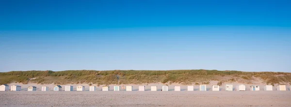 Strandstugor på holländska Vadden ön texel i skymningen under blå himmel på sommaren — Stockfoto