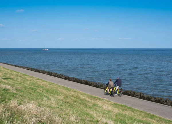 Paar fietstochten op dijk van waddenzee op Nederlands eiland texel in de zomer — Stockfoto