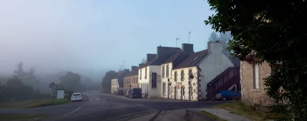 Villaggio lungo la strada in Bretagna centrale al mattino presto nebbioso — Foto Stock