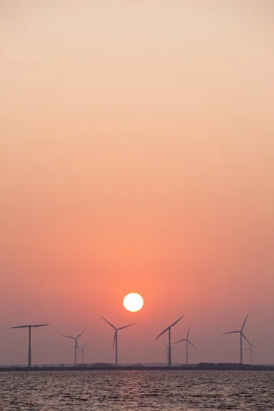 Wind turbines and sun in colorful sky — Stock Photo, Image
