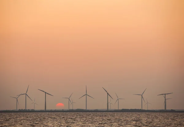 Turbine eoliche e sole nascente in cielo colorato — Foto Stock