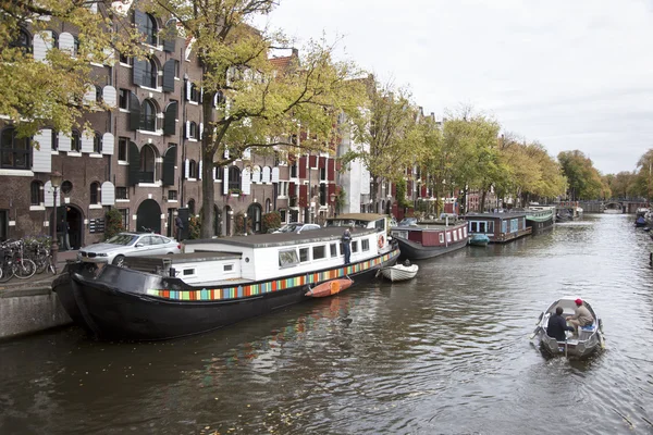 Small boat passing houseboats in brouwersgracht — Stock Photo, Image