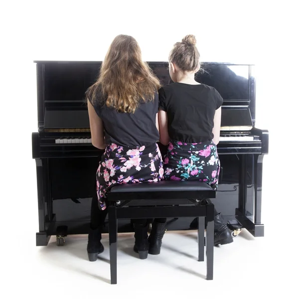 Két tizenéves lányok és fekete pianínó — Stock Fotó