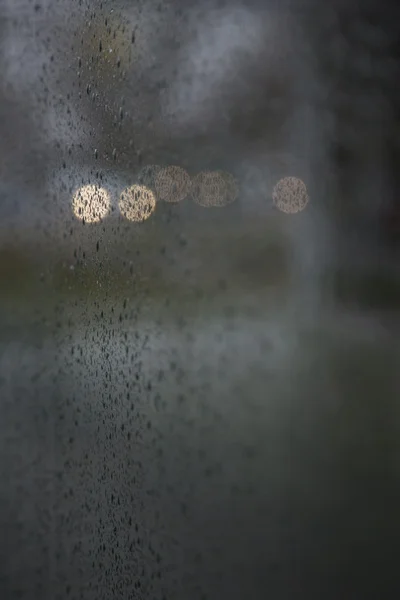Φώτα αυτοκινήτου ιδωμένη μέσα από το παρμπρίζ υγρό κατά τη διάρκεια βροχοπτώσεων — Φωτογραφία Αρχείου
