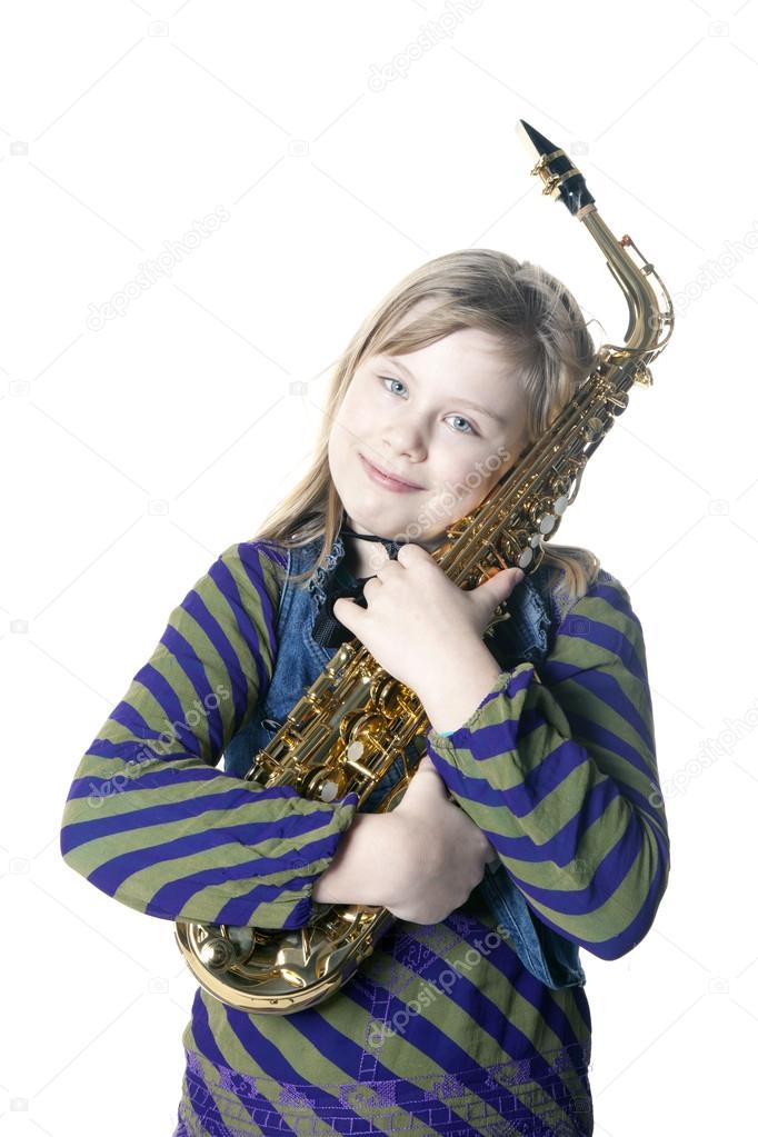 Young blond girl holds saxophone in studio