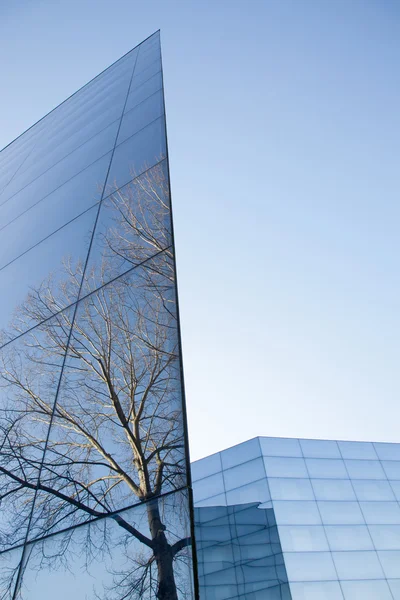 Façades de bâtiment moderne en verre avec des reflets du ciel bleu un — Photo