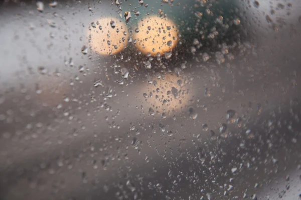 Fari di auto e riflessi visti attraverso vetro con raindr — Foto Stock