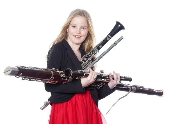 Young girl holds woodwind instruments in studio — Stock Photo, Image