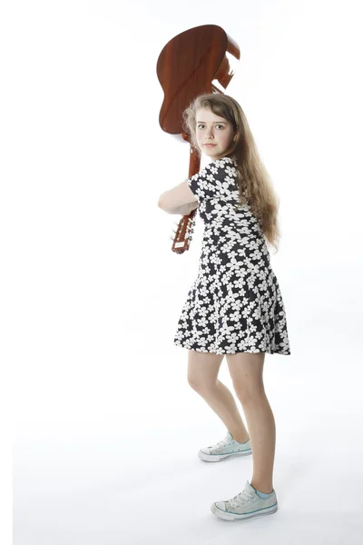 Sonriente adolescente en vestido columpios guitarra en estudio —  Fotos de Stock