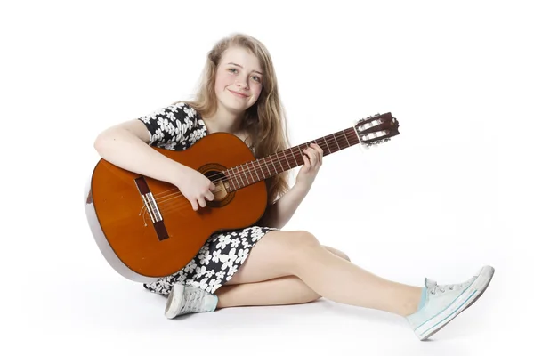 Smiling teenage girl in dress plays the guitar — Stock Photo, Image