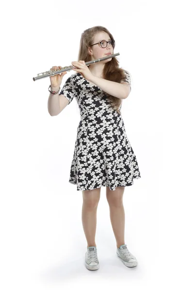 Teenage girl with glasses in dress plays the flute — Stock Photo, Image