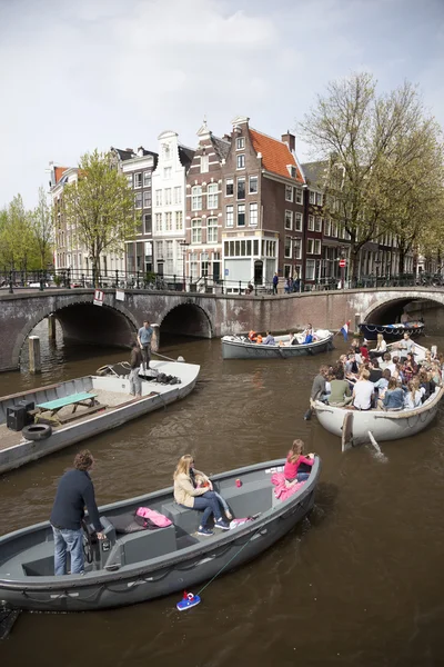 Many people on canal trip in centre of dutch capital amsterdam — Stock Photo, Image