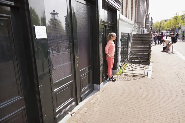 Toeristische meisje poseren voor oorspronkelijke anne frank huis in amsterdam — Stockfoto