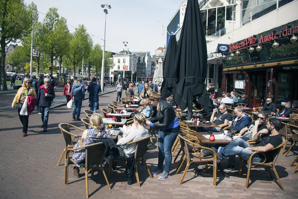 Ludzie w Amsterdamie cieszyć się słoneczny dzień na placu rembrandtplein — Zdjęcie stockowe