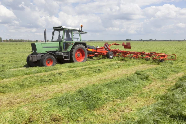 Piros széna turner, a zöld rét, Hollandia — Stock Fotó