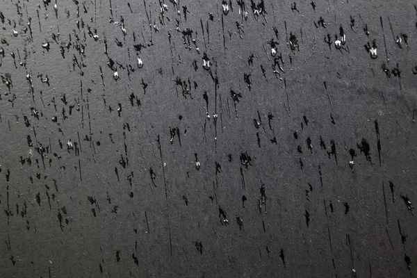 Padrão de gotas de chuva na superfície preta — Fotografia de Stock