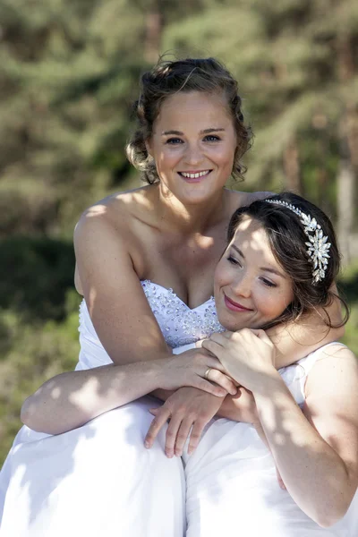 Dos novias sonríen y se abrazan en la naturaleza —  Fotos de Stock