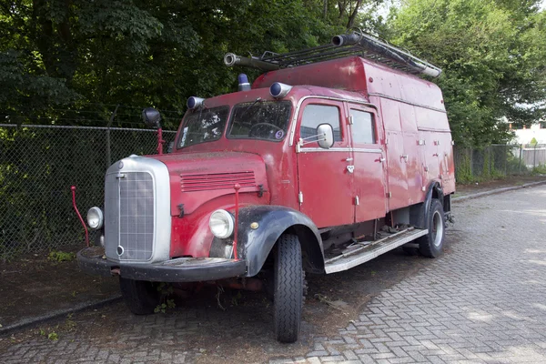 Velho caminhão de bombeiros vermelho estacionado nas terras baixas — Fotografia de Stock