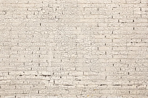 Brick wall with white paint full of cracks — Stock Photo, Image