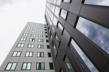 Modern cephe ofis binaları ve bulutlarda yansımaları 