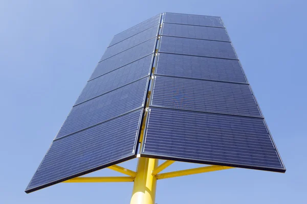 Solar panels on yellow metal stand and blue sky — Stock Photo, Image