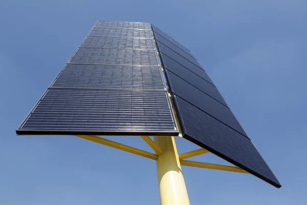 Solar panels on yellow metal stand and blue sky — Stock Photo, Image
