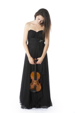 brunette stands and holds violin in studio against white backgro